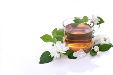 Jasmine tea. A traditional drink in China for health and vitality. Oriental medicine. Fresh jasmine flowers on white background and a cup of tea. Free space for text. Photos of light colors