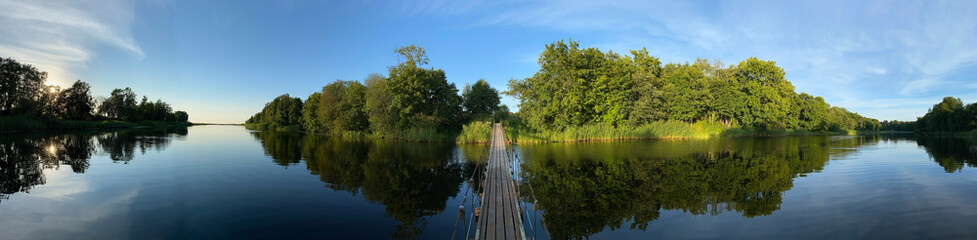 Fototapeta na wymiar panoramic photo of a hanging bridge over the river