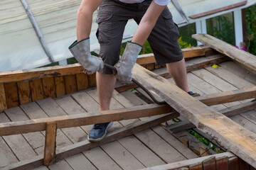dismantling the roof. The worker removes old boards