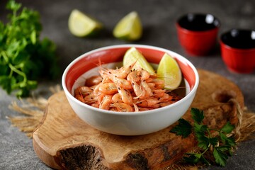 Fresh boiled sea shrimp with lime slices.