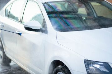 Summer car wash. Cleaning the car using high pressure water. Car wash with soap. Close up concept. Security measures during the epidemic. Concept disinfection and antiseptic cleaning. Car wash.