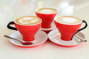 Three red coffee cups are on the table