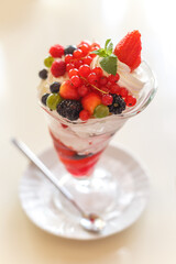 Berry dessert with cream and cream in a crystal vase