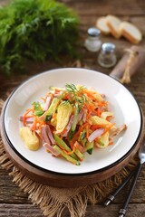 Salad of egg pancakes, smoked ham, cucumber and pickled carrots.
