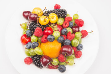 assortment of fresh berries on a white plate. useful vitamin healthy food fruit. healthy vegetable breakfast