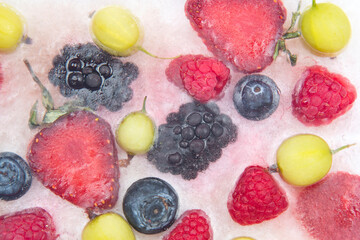 different juicy berries frozen in ice. useful vitamin healthy food fruit