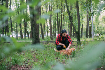 A man walks in the park with his cat on a harness