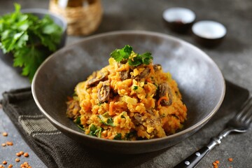 Braised chicken hearts with onions, carrots, zucchini and lentils. Healthly food.