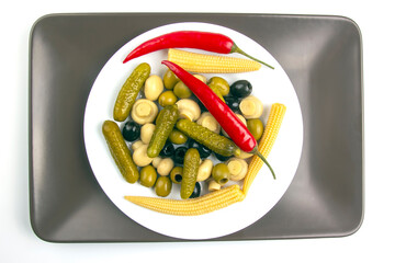 Olives, pickled cucumber, pepper, mushrooms and corn in a salad on a plate. food and vegetables. diet and weight loss
