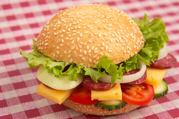 Hamburger with vegetables and sausage. Fast food and breakfast. Calories and diet.