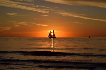 Papier Peint photo autocollant Clearwater Beach, Floride Silhouette of a sailboat eclipsing sunset at clearwater beach