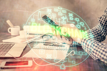 Double exposure of man's hands holding and using a phone and crypto currency blockchain theme drawing.