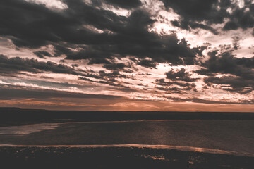 Fototapeta premium Dramatic sky over the coast at sunset