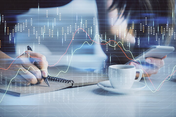 Double exposure of forex graph sketch hologram and woman holding and using a mobile device. Stock market concept.