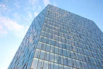 Fototapeta na wymiar Glass facade of a modern multi-storey building against the sky