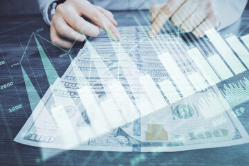 Multi exposure of forex graph drawing hologram and USA dollars bills and man hands. Technical Analysis concept.