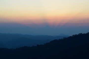 Kausani, Uttarakhand, India, Sunrise with crown-shaped light rays amidst the Himalayan mountains