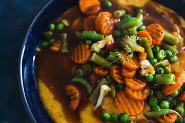 plant-based food, vegan roasted veggies with polenta dish and mushroom gravy