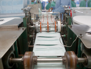 Factory workers are producing masks for protection against viruses.