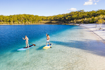 Couple stand up paddle boarding  on Lake Mckenzie
