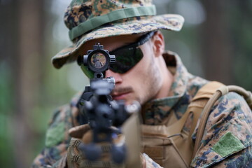 soldier in action aiming  on weapon  laser sight optics