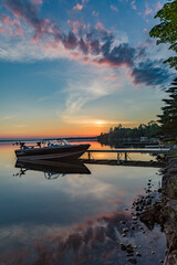 Cottage vacation holiday with a beautiful early sunrise overlooking the fishing boat and dock in...
