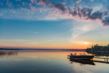 Cottage vacation holiday with a beautiful early sunrise overlooking the fishing boat and dock in Canada, Balsam Lake in Kawartha Lakes  © Katherine Kalmbach