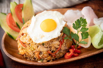 nasi goreng, indonesian fried rice on wooden plate