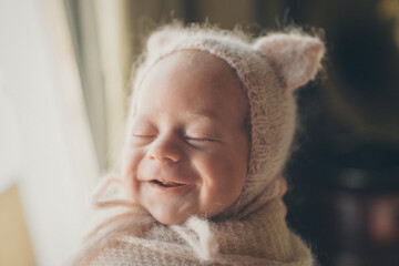a newborn baby is smiling. A small child in a hat with ears. children's fashion