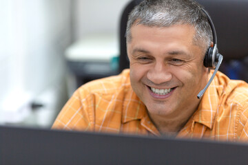Online working concept. Smiley man with headset having online conversation.
