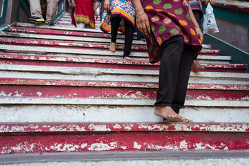 unrecognizable hindu women feet going down stairs from Batu Caves hindu temple - Powered by Adobe