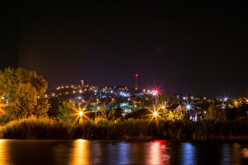 Night panorama of Lake Velence and illuminated Bence-hill view, Stars, lake and hill at night in Velence, Hungary