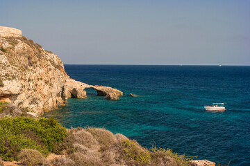 Fototapeta na wymiar Rock arch and a boat in Comino island