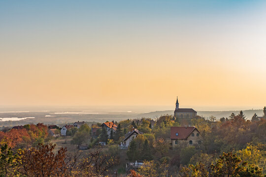 The Catholic Church of Sukoro and Lake Velence at sunset in autumn