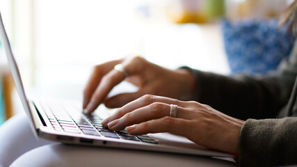 Young Woman's hands typing on a keyboard notebook