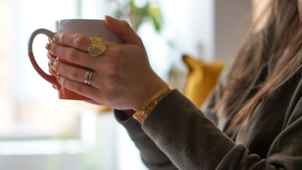 Woman's hands holding a cup of coffee with her two hands