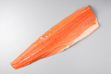 Fresh raw salmon fish steak with spices on ice over dark stone background. Creative layout made of fish, top view, flat lay