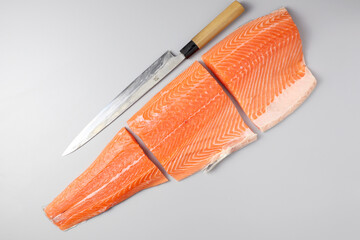 Fresh raw salmon fish steak with spices on ice over dark stone background. Creative layout made of fish, top view, flat lay