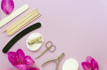 Obraz na płótnie Canvas Flat lay of manicure accessories with flowers on a lilac background. Space for text