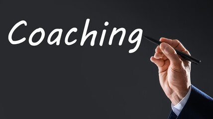 Business trainer writing word Coaching on virtual screen, closeup. Banner design