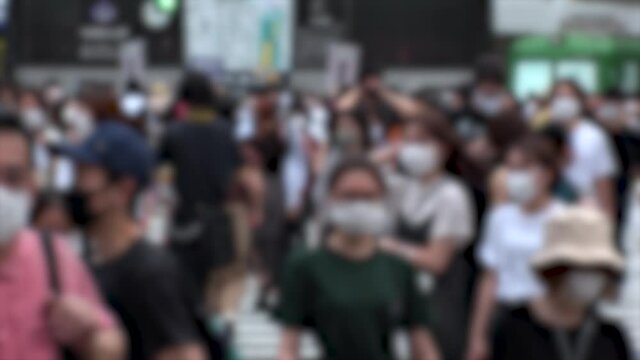 SHIBUYA, TOKYO, JAPAN - AUG 2020 : Crowd of people wearing surgical mask to protect from Coronavirus (COVID-19) at Shibuya Crossing. Shot in day time, hot summer season. Blurred shot.