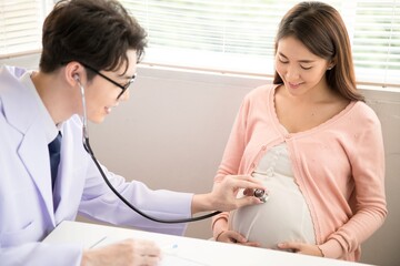Male doctor examining a pregnant female patient