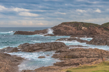 Rocky Seascape with Blue Aquamarine Sea and Earthy Brown Rocks