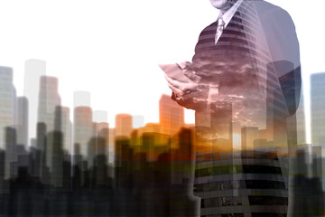 Obraz premium Double Exposure of Businessman hold Digital Wireless Table with City Building and Skyscraper as Concept of Real Estate or Technology business administration.