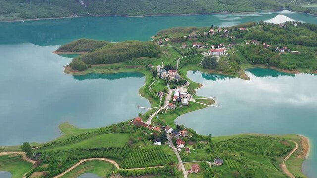 Slow flying backwards. Revealing a beautiful scenery of lake Rama, Bosnia. Foggy Spring day.