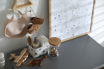 Wooden toys and different accessories on grey table in child room