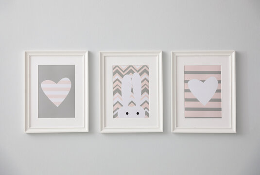 Different cute pictures on grey wall. Baby room interior