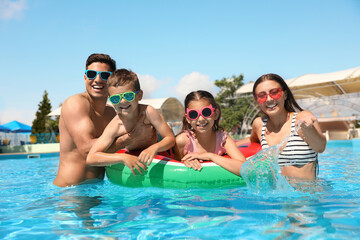 Obraz na płótnie Canvas Happy family in swimming pool. Summer vacation