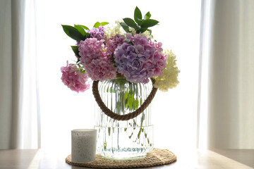 Bouquet of beautiful hydrangea flowers on table near window. Interior design