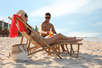 Couple resting on sunny beach at resort